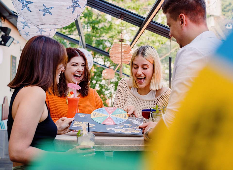 Freunde freuen sich über die Auswahl die sie mit der "spin the wheel" Karte getroffen haben