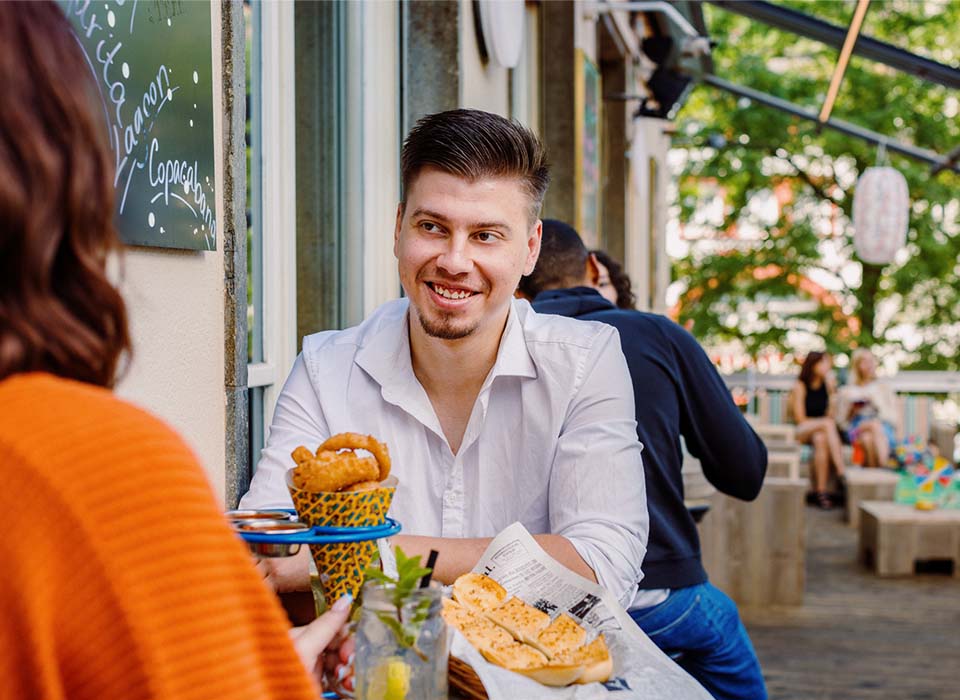 Ein Paar geniesst Snacks und Drinks auf der Papa Joe's Terrasse in Basel